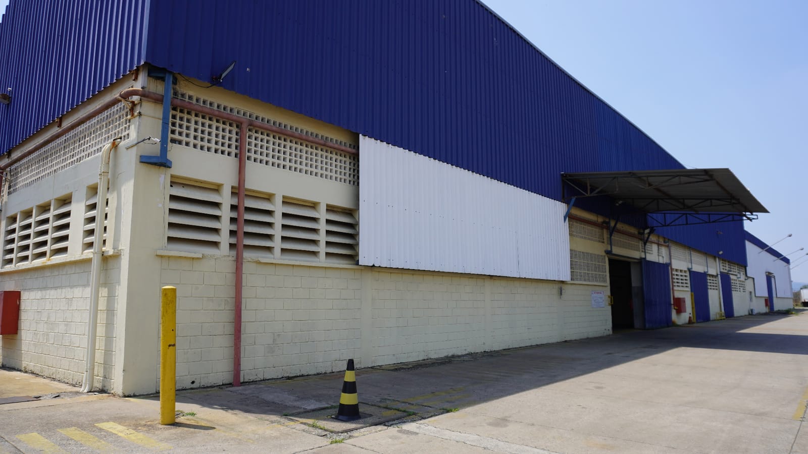 Estrutura lateral do galpão da Primeserv com acesso operacional